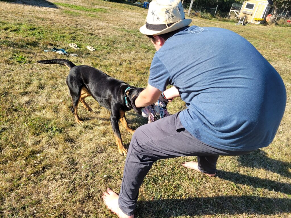 Luna playing tug with a teenage boy